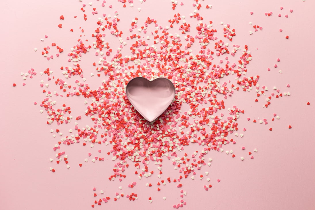 Heart shaped baking tin with small confetti on surface for Valentine day